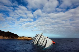 The Costa Concordia cruise ship which ran aground off the west coast of Italy at Giglio island lies on its side, half-submerged and threatening to slide into deeper waters